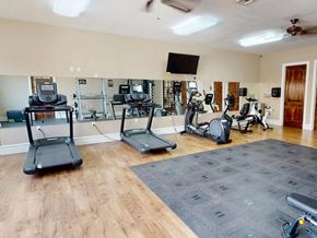 Hobbs apartment for rent - A gym with treadmills, elliptical machines, and a television.