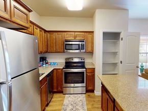 Hobbs apartment for rent - A kitchen with wooden cabinets and a stainless steel refrigerator.