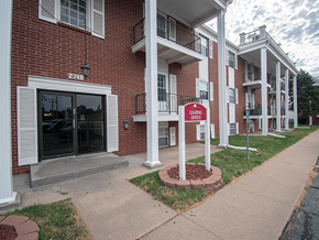 Wichita apartment for rent - A red sign that says Leasing Office stands in front of a brick building.