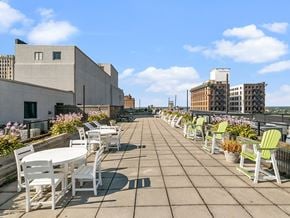 Toledo apartment for rent - a roof terrace with tables and chairs and buildings in the background