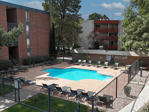 Albuquerque apartment for rent - A pool surrounded by chairs and a fence.