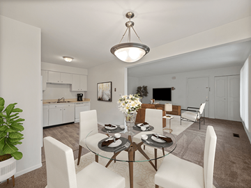Flint apartment for rent - A modern dining room with a glass table and white chairs.