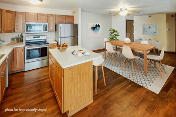Jamestown apartment for rent - A kitchen with wooden cabinets and a wooden island with chairs around it.
