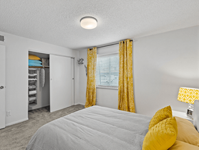 Kansas City apartment for rent - apartment bedroom with a bed and yellow curtains and a closet