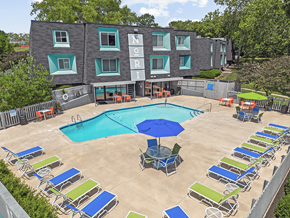 Kansas City apartment for rent - an aerial view of a swimming pool and patio with chairs and an umbrella