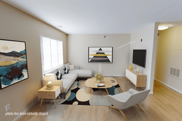 Bismarck apartment for rent - A living room with a white couch, a coffee table, and a painting on the wall.