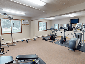 St. Cloud apartment for rent - A spacious gym with a variety of equipment including treadmills, stationary bikes, and weight machines.