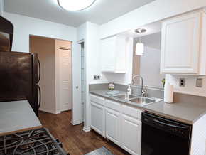 Grand Rapids townhouse for rent - a kitchen with white cabinets and a sink and a refrigerator