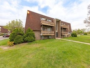 Sandusky apartment for rent - A large building with a red roof and a green lawn in front.