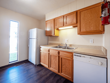 Parkersburg apartment for rent - A kitchen with wooden cabinets and a white dishwasher.