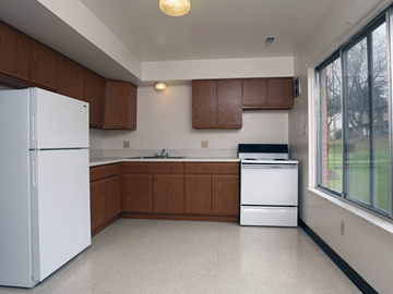 Mansfield townhouse for rent - A kitchen with white appliances and brown cabinets.