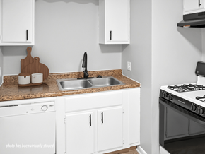 Omaha apartment for rent - A kitchen with white cabinets and a black stove top.