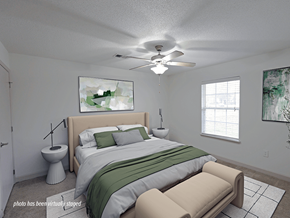 Fayetteville apartment for rent - A bedroom with a bed, a chair, and a painting on the wall.