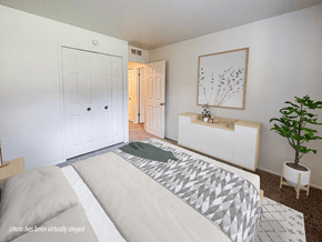 Keego Harbor apartment for rent - A bedroom with a large bed and a plant.