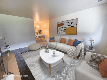 Keego Harbor apartment for rent - A living room with a white couch, a coffee table, and a painting on the wall.