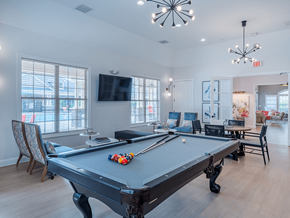 Fayetteville apartment for rent - A pool table is in the middle of a room with a television and chairs.