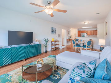 Fayetteville apartment for rent - A living room with a white couch and a green patterned cabinet.