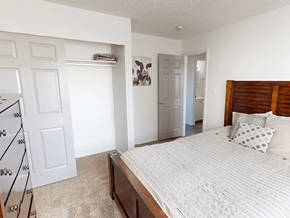 Greeley apartment for rent - A bedroom with a large bed and a dresser.
