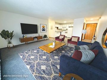 Saint Cloud apartment for rent - A living room with a blue couch and a wooden coffee table.