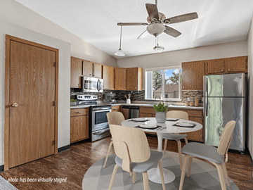Rapid City apartment for rent - A kitchen with a table and chairs in the middle of the room.