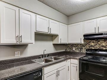 West Columbia apartment for rent - A kitchen with white cabinets and a black stove top oven.