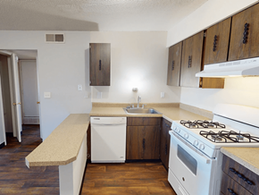 Florissant townhouse for rent - A kitchen with a white stove top oven and a white dishwasher.