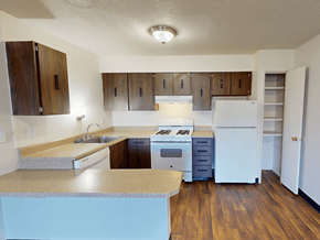 Florissant townhouse for rent - A kitchen with wooden cabinets and a white refrigerator.