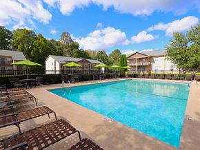 Burlington apartment for rent - a resort style pool with chairs and umbrellas next to a building