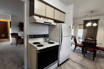 Lapeer apartment for rent - A modern kitchen with a white refrigerator and stove top oven.