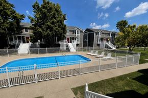 Springfield apartment for rent - A pool surrounded by a fence with a building in the background.