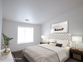 Kentwood apartment for rent - A bedroom with a large bed and a painting above it.
