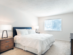 Mishawaka townhouse for rent - A bedroom with a bed, nightstands, and a window.
