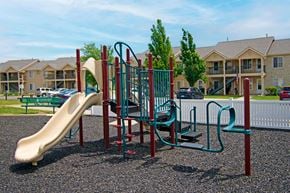 Wichita townhouse for rent - A playground with a slide, swings, and a climbing frame.
