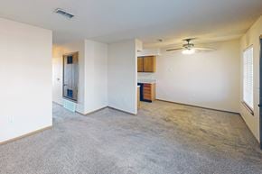 Wichita townhouse for rent - A spacious living room with a carpeted floor and a ceiling fan.
