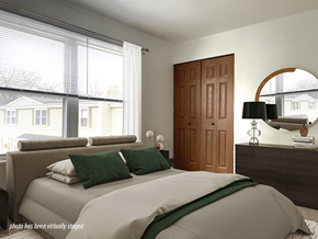 Grand Rapids townhouse for rent - A bedroom with a large bed and a wooden door.