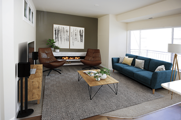 Bismarck apartment for rent - A living room with a blue couch and a fireplace.