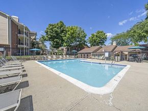 Kettering apartment for rent - a swimming pool with chairs around it in front of a building