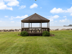 Sandusky apartment for rent - a gazebo with a table and chairs on a lawn near the water
