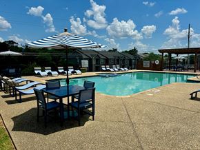 Longview apartment for rent - a swimming pool with a table and chairs and an umbrella