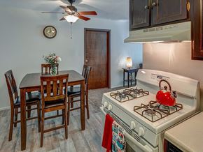Burnsville apartment for rent - A kitchen with a white gas stove and a dining table with chairs.