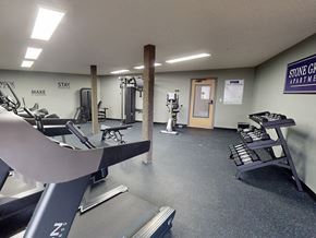 Burnsville apartment for rent - A gym room with a treadmill, weights, and a bench.