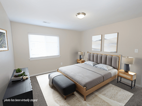 Greenville apartment for rent - A bedroom with a large bed and a nightstand with a lamp.