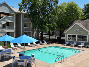 St. Louis apartment for rent - A pool surrounded by chairs and umbrellas in front of apartment buildings.