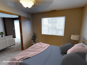 Minot apartment for rent - A bedroom with a bed, a chair, and a lamp.