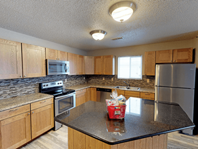Minot apartment for rent - apartment kitchen with a granite counter top and wooden cabinets