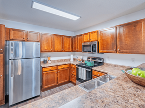 Fayetteville apartment for rent - A kitchen with wooden cabinets and a stainless steel refrigerator.