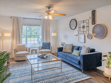 Fayetteville apartment for rent - A living room with a blue couch and a glass coffee table.