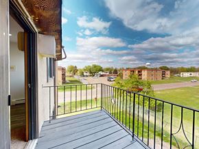 Brooklyn Center apartment for rent - A balcony with a view of a parking lot and buildings.