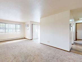 Brooklyn Center apartment for rent - A spacious room with a carpeted floor and a sliding glass door.