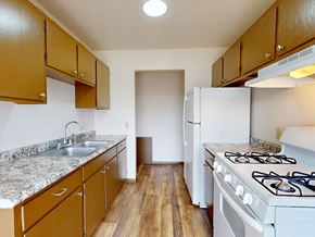 Brooklyn Center apartment for rent - A kitchen with a white stove and brown cabinets.